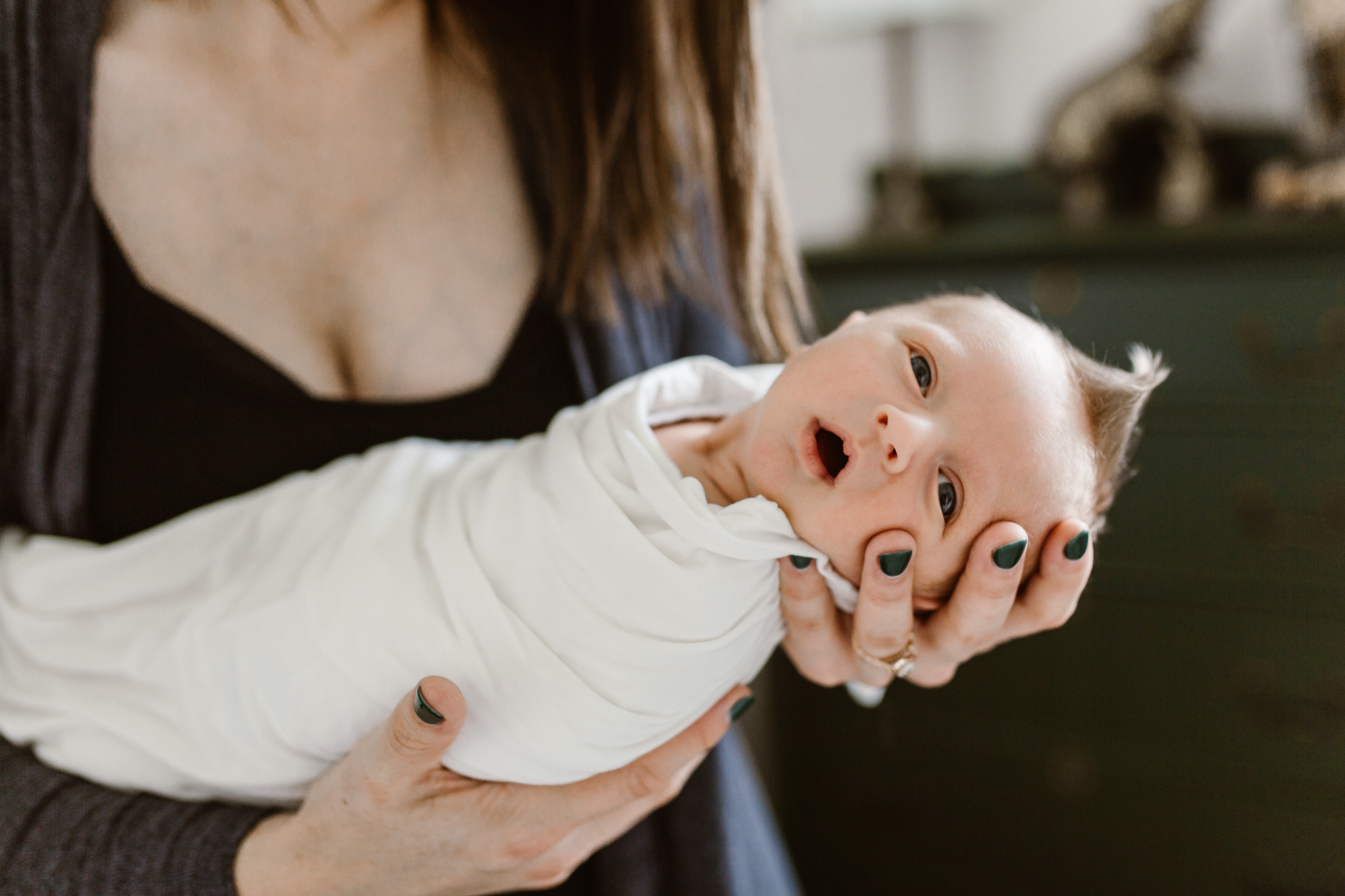 Mother holding her new baby boy in her hands.